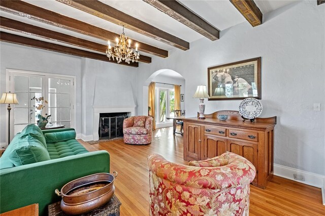 6010 17th Ave S, Gulfport, FL 33707 - living room featuring an inviting chandelier, beam ceiling, and light wood-type flooring
