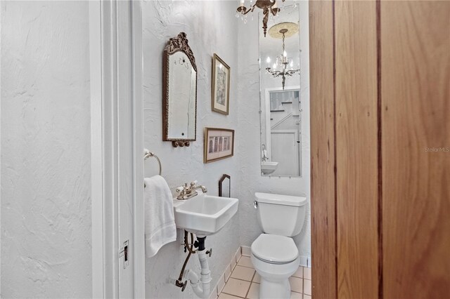 6010 17th Ave S, Gulfport, FL 33707 - bathroom featuring tile patterned flooring, a notable chandelier, and toilet