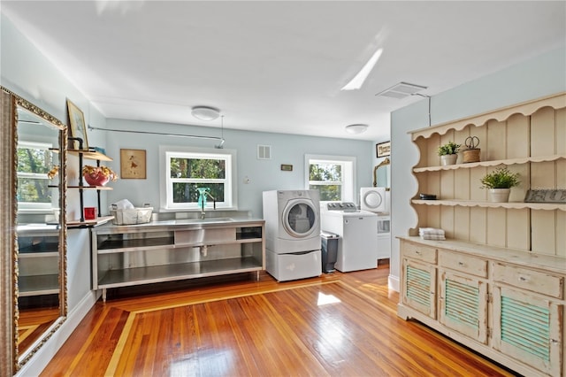 6010 17th Ave S, Gulfport, FL 33707 - clothes washing area featuring plenty of natural light, sink, light hardwood / wood-style floors, and washer and dryer