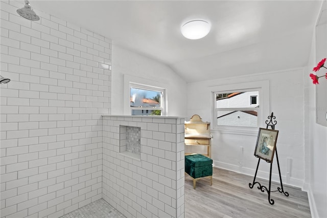 6010 17th Ave S, Gulfport, FL 33707 - bathroom featuring lofted ceiling, hardwood / wood-style flooring, and a tile shower