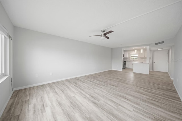 unfurnished living room featuring ceiling fan and light wood-type flooring