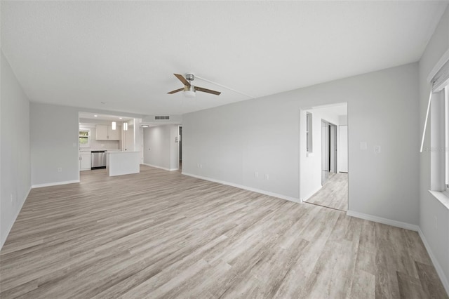 unfurnished living room featuring ceiling fan and light wood-type flooring