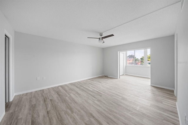 empty room featuring ceiling fan, a textured ceiling, and light hardwood / wood-style flooring