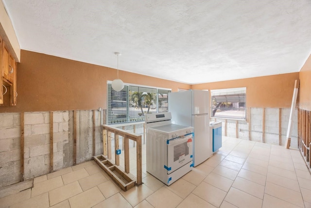 kitchen featuring pendant lighting, white appliances, kitchen peninsula, and a textured ceiling