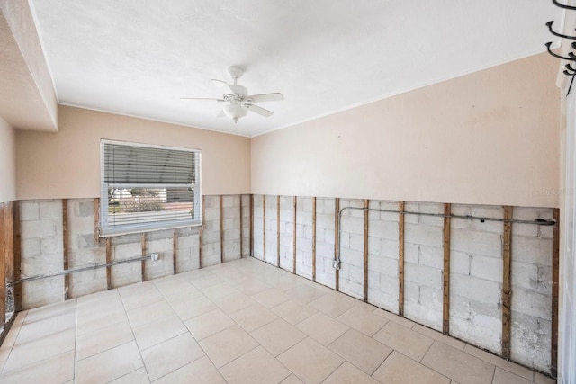 empty room featuring light tile patterned floors, ornamental molding, and ceiling fan