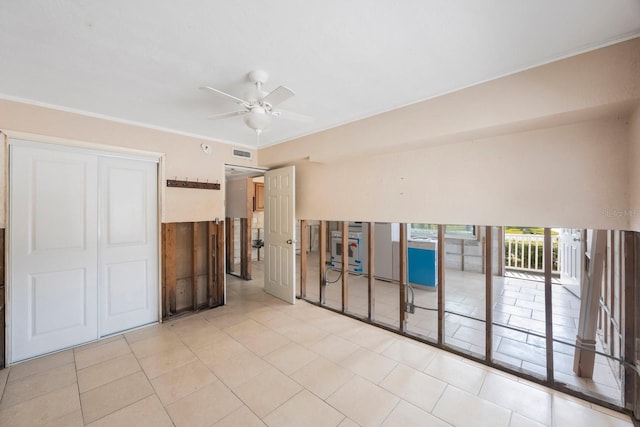 tiled spare room with crown molding and ceiling fan