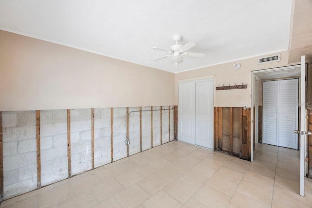 unfurnished bedroom with crown molding, a closet, and ceiling fan