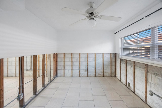 tiled empty room featuring ceiling fan