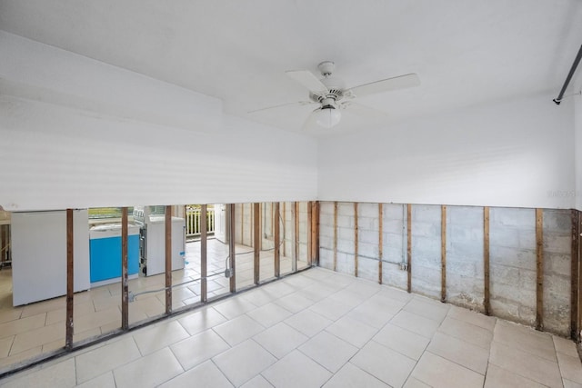 empty room with washer / clothes dryer, light tile patterned flooring, and ceiling fan