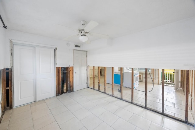 tiled spare room with washer / dryer and ceiling fan