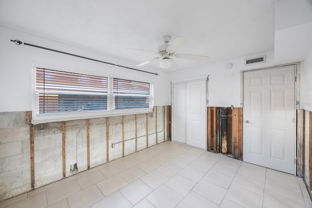 tiled spare room featuring ceiling fan