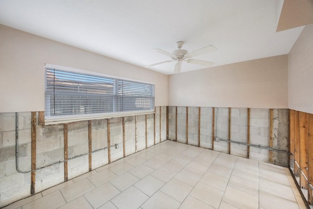 tiled empty room featuring ceiling fan