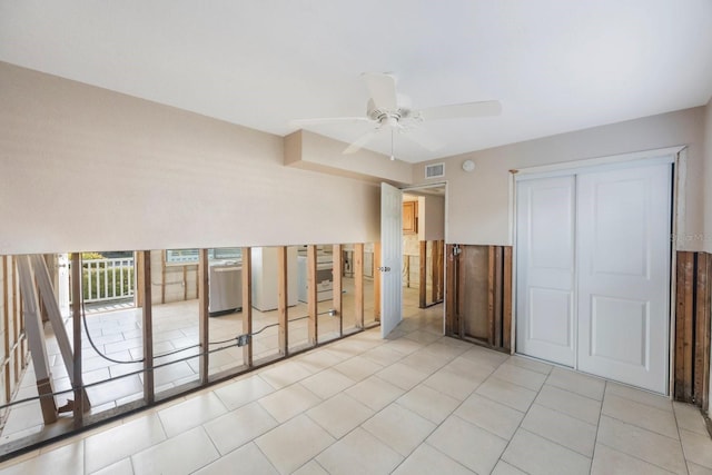 tiled empty room featuring ceiling fan