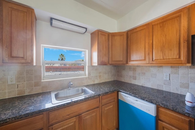 kitchen with tasteful backsplash, white dishwasher, sink, and dark stone countertops