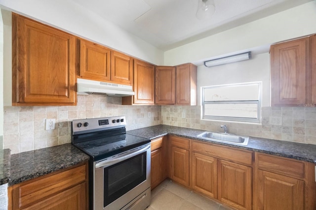 kitchen with light tile patterned flooring, sink, backsplash, dark stone counters, and electric stove