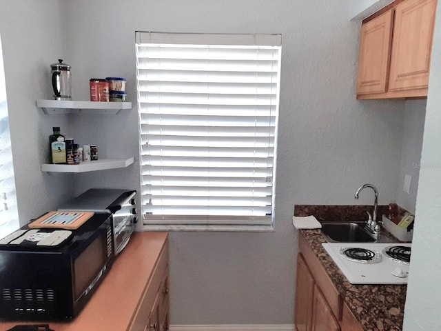 kitchen with sink, a wealth of natural light, white stovetop, and light brown cabinets