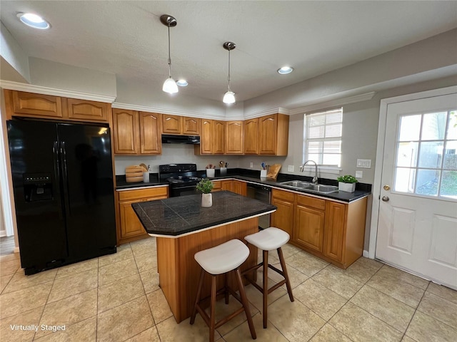 kitchen featuring pendant lighting, sink, a breakfast bar area, black appliances, and a kitchen island