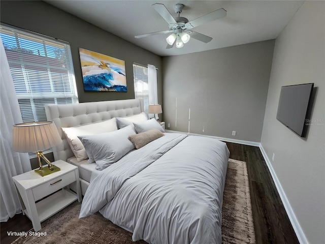 bedroom with dark hardwood / wood-style flooring and ceiling fan