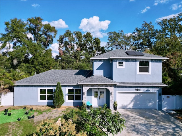 view of front property with a garage and solar panels