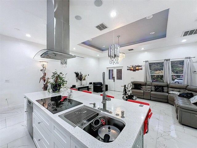 3911 Auburndale Ave, Orlando, FL 32839 - kitchen with pendant lighting, island range hood, white cabinets, black electric cooktop, and a raised ceiling