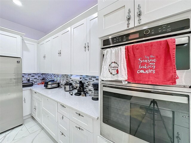 3911 Auburndale Ave, Orlando, FL 32839 - kitchen featuring stainless steel appliances, white cabinetry, and decorative backsplash