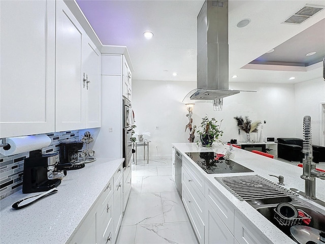 3911 Auburndale Ave, Orlando, FL 32839 - kitchen with black electric stovetop, island range hood, white cabinets, and decorative backsplash
