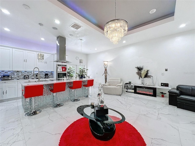 3911 Auburndale Ave, Orlando, FL 32839 - kitchen with a breakfast bar area, a kitchen island with sink, island range hood, and decorative light fixtures