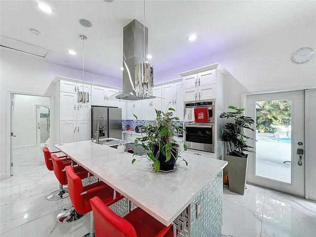 3911 Auburndale Ave, Orlando, FL 32839 - kitchen with a kitchen bar, white cabinetry, pendant lighting, island exhaust hood, and a kitchen island with sink
