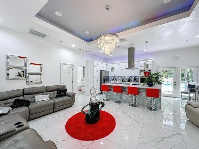 3911 Auburndale Ave, Orlando, FL 32839 - living room with french doors, a textured ceiling, an inviting chandelier, and a tray ceiling