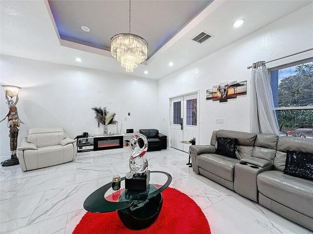 3911 Auburndale Ave, Orlando, FL 32839 - living room featuring french doors, a tray ceiling, and a notable chandelier