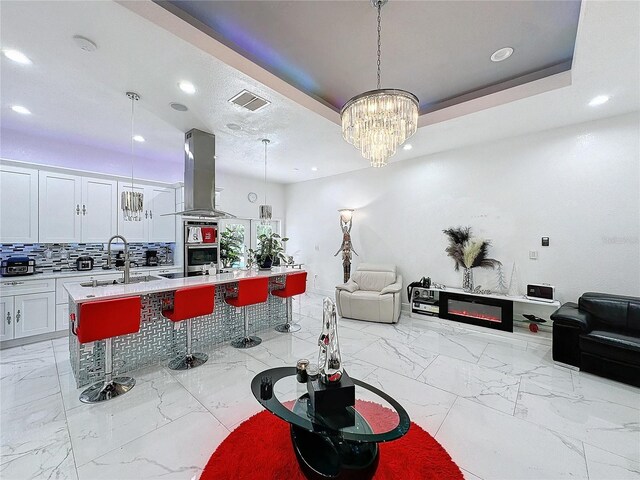 3911 Auburndale Ave, Orlando, FL 32839 - kitchen with pendant lighting, island exhaust hood, a breakfast bar, and a center island with sink