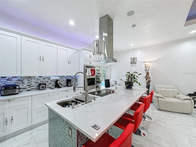 3911 Auburndale Ave, Orlando, FL 32839 - kitchen featuring white cabinetry, a center island with sink, a kitchen breakfast bar, and decorative light fixtures