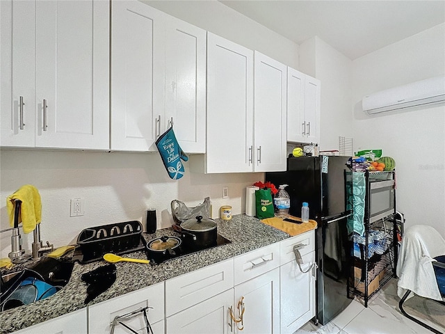 3911 Auburndale Ave, Orlando, FL 32839 - kitchen with white cabinetry, black fridge, a wall mounted AC, and dark stone countertops