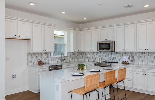 5295 SW 87th Ter, Ocala, FL 34481 - kitchen featuring stainless steel microwave, a sink, dishwashing machine, white cabinetry, and recessed lighting