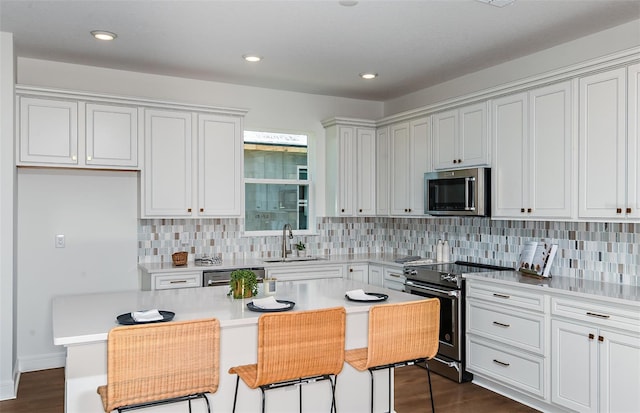 5295 SW 87th Ter, Ocala, FL 34481 - kitchen with appliances with stainless steel finishes, a sink, decorative backsplash, light countertops, and white cabinetry