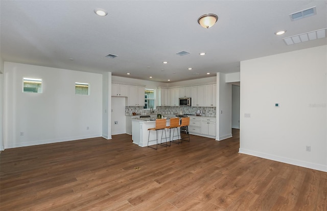 5295 SW 87th Ter, Ocala, FL 34481 - kitchen with appliances with stainless steel finishes, decorative backsplash, white cabinetry, a kitchen bar, and recessed lighting