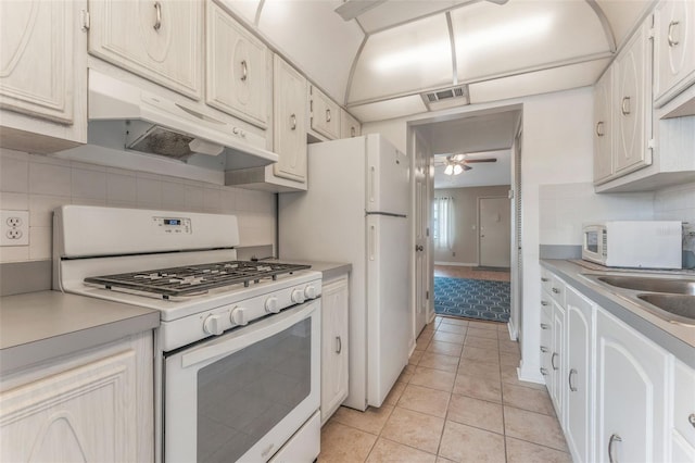 kitchen with sink, tasteful backsplash, white appliances, light tile patterned floors, and ceiling fan