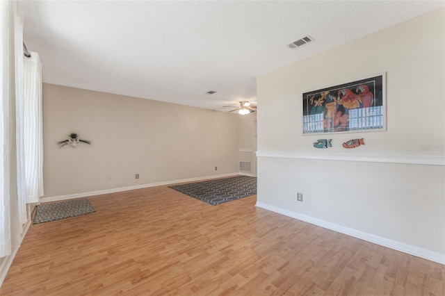 empty room featuring ceiling fan, a textured ceiling, and light wood-type flooring