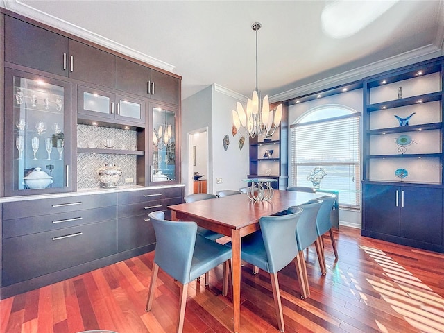 dining room featuring crown molding, hardwood / wood-style flooring, and a chandelier