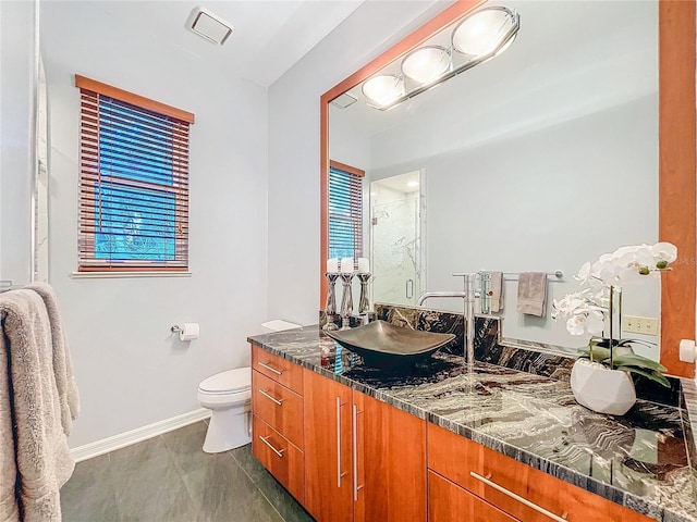 bathroom featuring vanity, a shower with shower door, and toilet