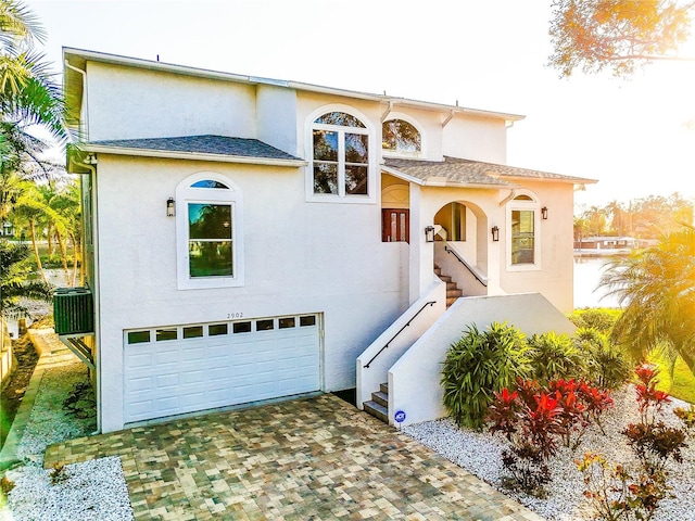 mediterranean / spanish house with a garage and central AC unit