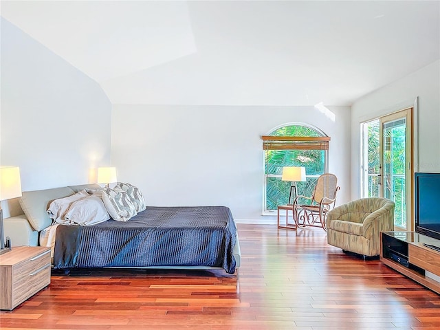 bedroom with lofted ceiling, wood-type flooring, and access to outside