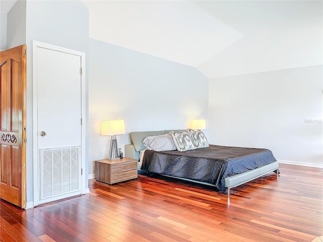 bedroom featuring lofted ceiling and hardwood / wood-style floors