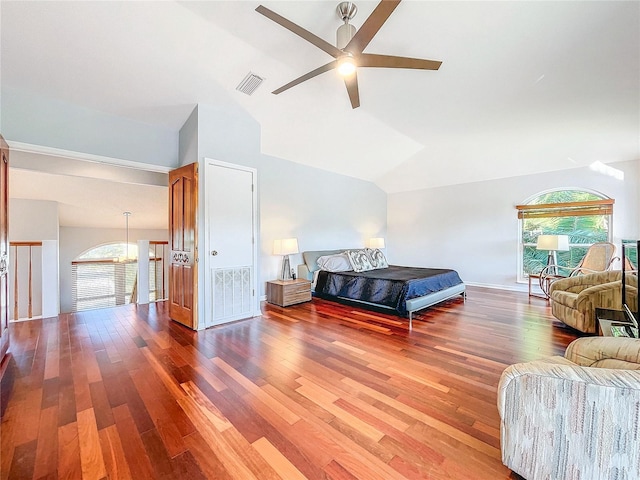 bedroom with ceiling fan, hardwood / wood-style floors, vaulted ceiling, and multiple windows