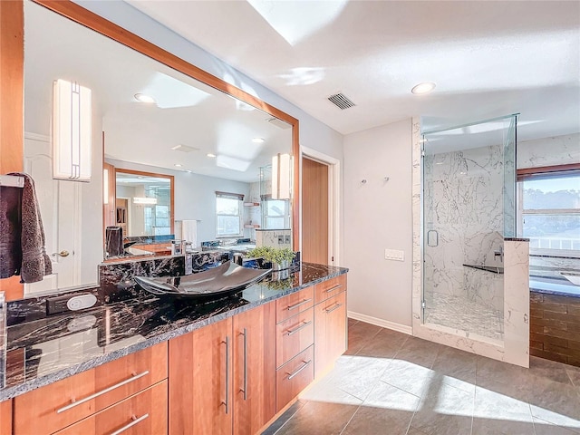 bathroom with vanity, an enclosed shower, and a wealth of natural light