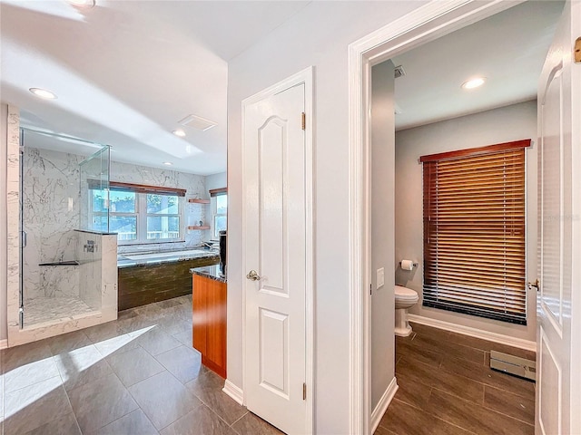 bathroom featuring wood-type flooring, independent shower and bath, and toilet