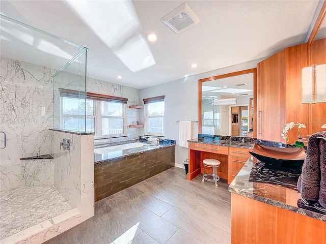 bathroom featuring vanity and independent shower and bath