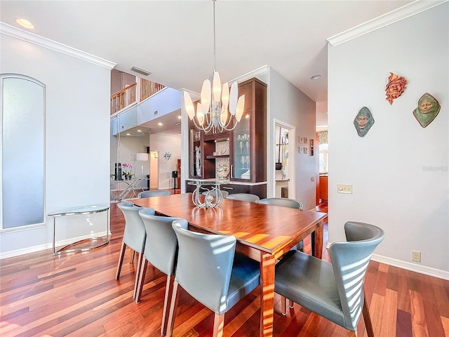 dining area featuring hardwood / wood-style floors, a notable chandelier, and ornamental molding