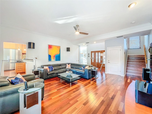 living room featuring ceiling fan, crown molding, and light hardwood / wood-style floors