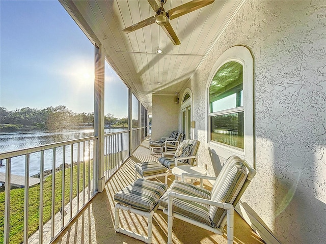 balcony with a water view and ceiling fan